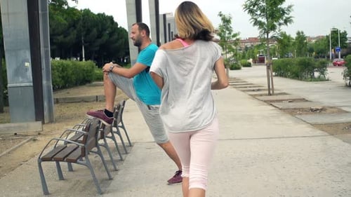 City joggers super slow motion man stretching legs woman running workout