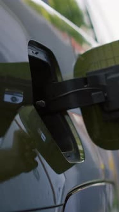 Vertical Video Close Up of Driver Opening Electric Vehicle Charging Port Flap to Charge Battery