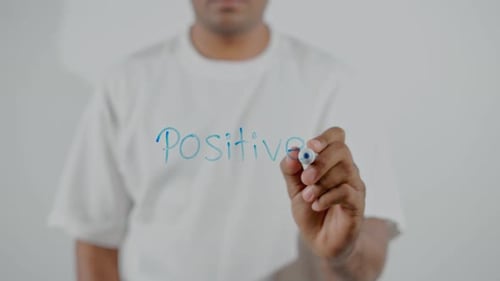 Person Writes Positive Message on Clear Surface
