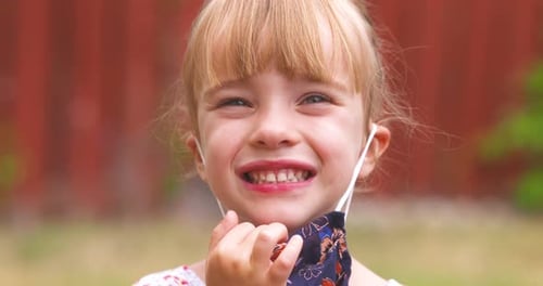 Child Puts On a Patterned Face Mask