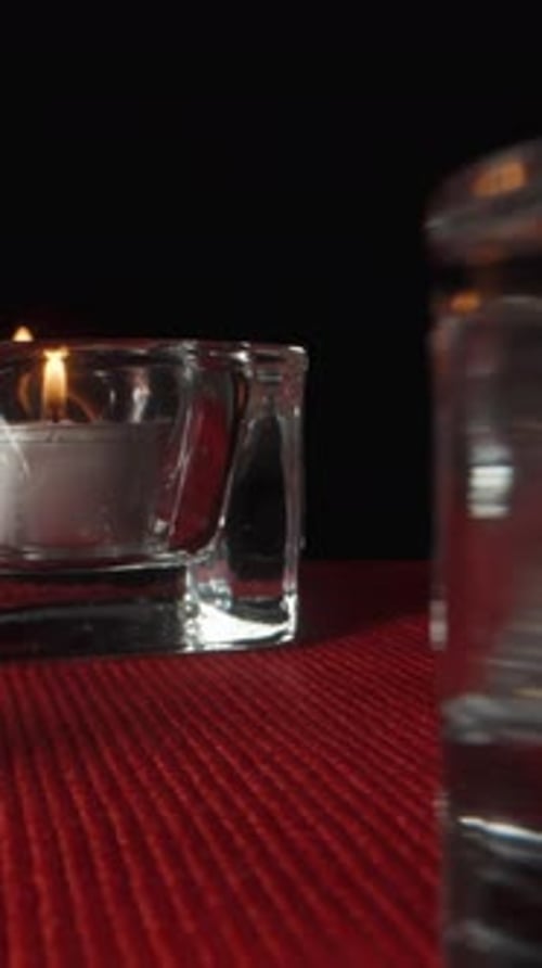 I light red candles in glass candlesticks in turn. Dolly slider extreme close-up inside. Vertical vi