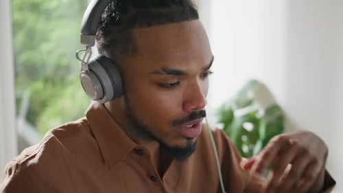Young man with headphones talking during video call