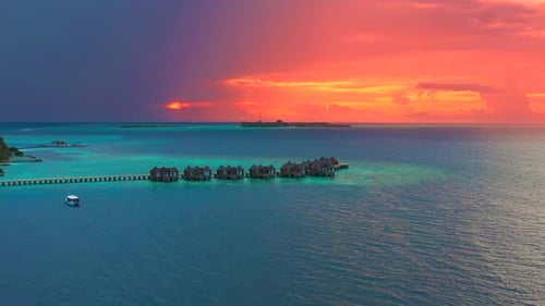 Overwater Villas at the Time Amazing Sunset in Tropical Sea with Coral Reef