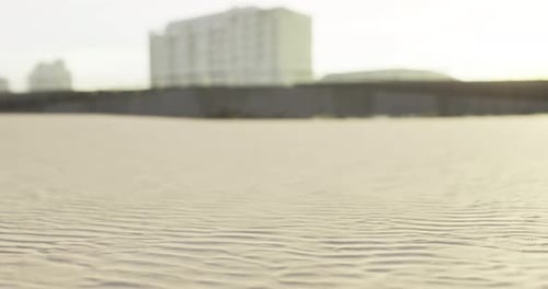 Sand Patterns on a Beach with Buildings in the Background at Sunset