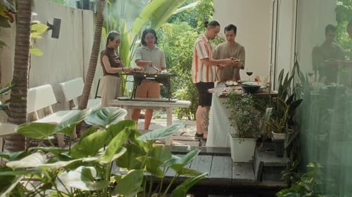 Friends Enjoying a Tropical Backyard Barbecue Together