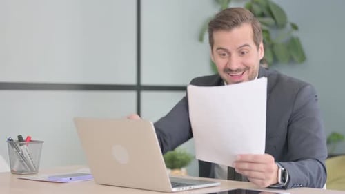 Successful Businessman Celebrating Good News in Office