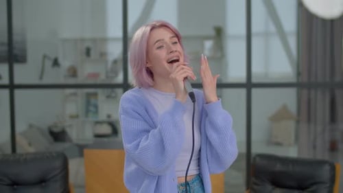 Young Woman Sings Passionately into Microphone Indoors