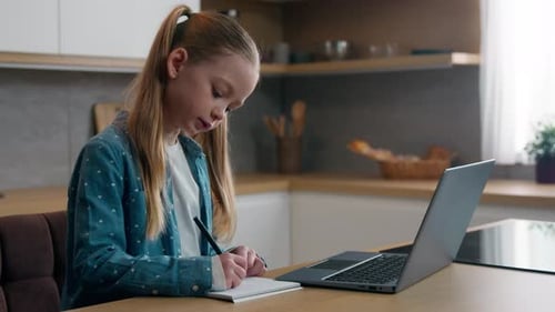 Caucasian Kid Girl Schoolgirl Watching Online Lesson School Class at Home Writing Homework Task at