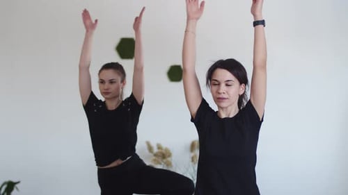 Women Group Performs Yoga Pose Under Guidance of Yoga Instructor at Fitness Club Front View