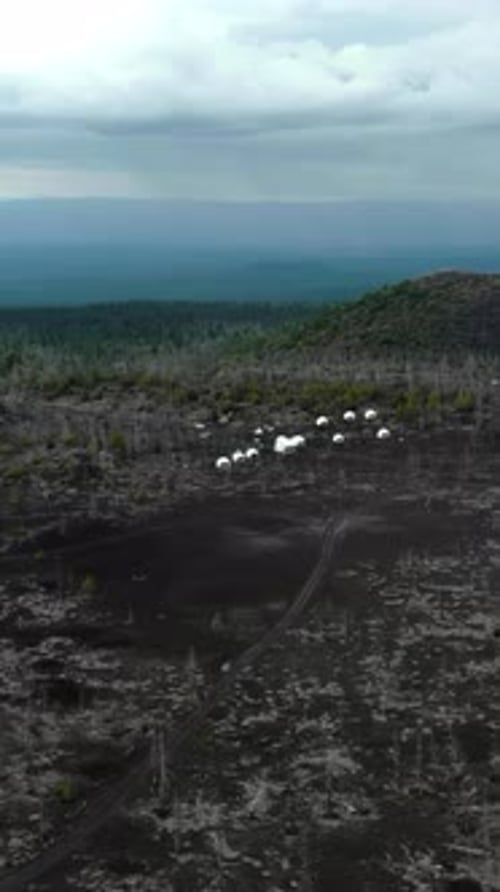 Aerial View of Glamping Tents in a Volcanic Landscape Media