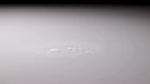 Desinfektionsspray wird auf eine weiße reflektierende Oberfläche gesprüht und mit einem Tuch abgewischt.