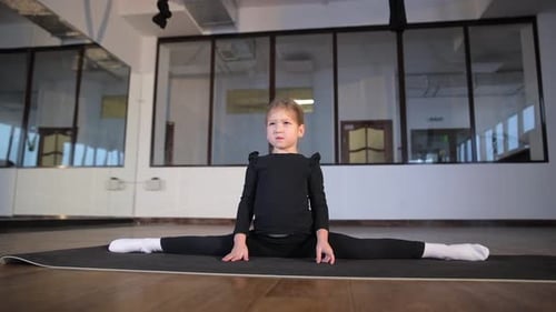 Child in Black Leotard Performs Straddle Split