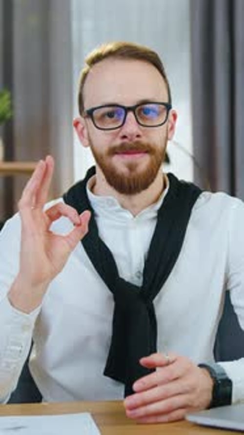 Portrait of Man Office Manager in Eyeglasses Which Poses on Camera and Showing Gesture Ok on the