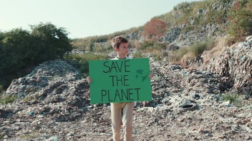 Child Holds 'Save the Planet' Sign in Landfill