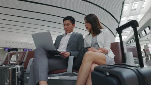 Couple Using Laptop in Modern Airport Waiting Area