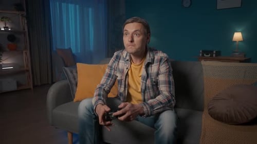 Man Playing Video Game at Night on Couch