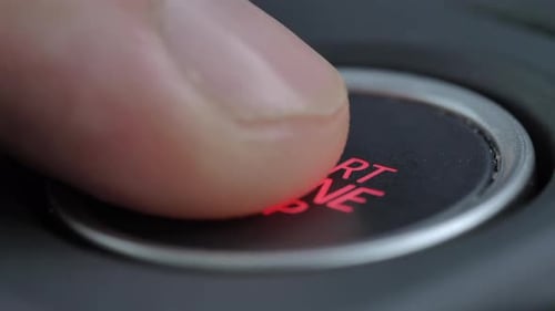 Drücken Sie den Autostartknopf mit dem Finger nach unten - Schlüsselloses Zündsystem. - Nahaufnahme