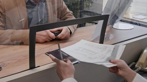 Close up of Bank Teller Handling Documents of Customer in Bank Office