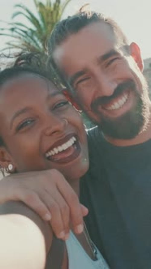 Primer plano de pareja interracial sonriente enamorada tomando una selfie