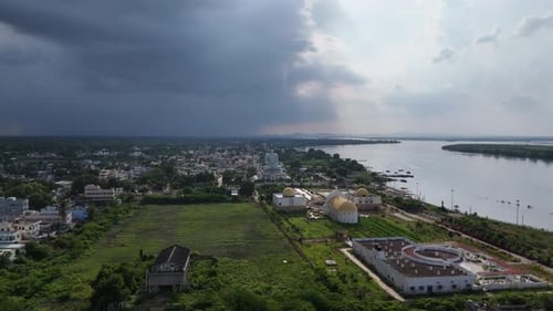 Vue imprenable par drone sur les toits de Vijayawada, encadrée par une colline calme et verdoyante à l'horizon.