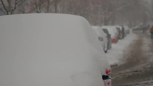 La neige recouvre les voitures et les rues de la ville dans un décor hivernal merveilleux