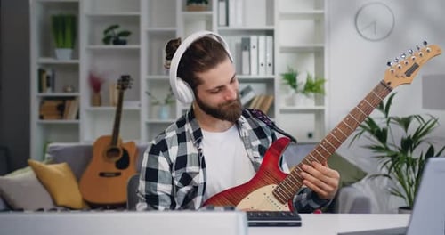 Creative Musician Talented Man Playing Electronic Guitar and Recording Music at Home Studio.