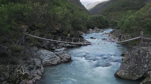 Epic Aerial View on Woman Walking Over Old Bridge