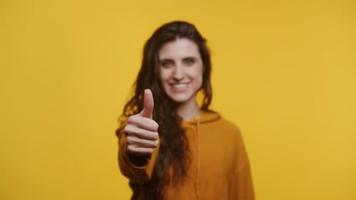 Woman Smiles and Gives a Thumbs Up