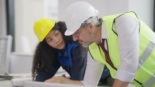 Engenheiros usando o plano de projeto, discutindo e trabalhando