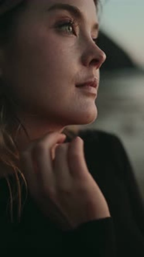 Closeup Of Woman Fixing Hair And Gazing At Sunset At Ocean Shore