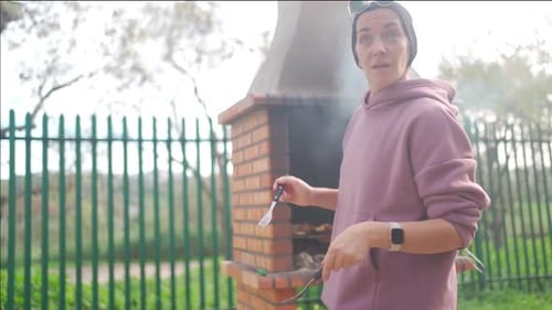 Mujer preparando parrilla de barbacoa al aire libre en el parque