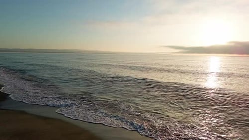 Black Sea and Beach Nearby Against a Sky with Clouds and a Dawn Sun