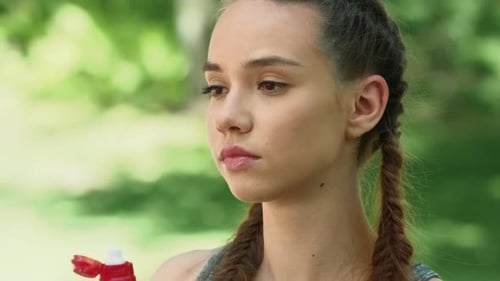 Fitness Woman Drinking Water From Bottle After Running Exercise in City Park