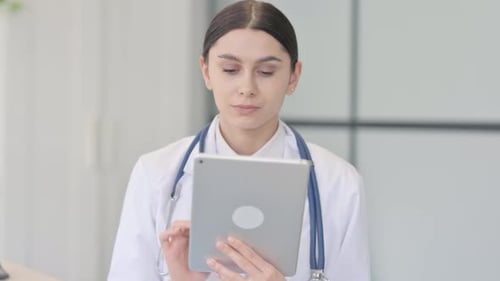 Female Doctor Using Tablet in Bright Office