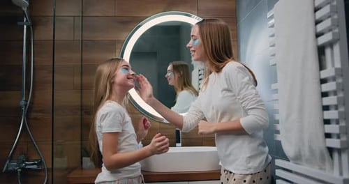 Girl and Young Woman Applying Cosmetic Patches