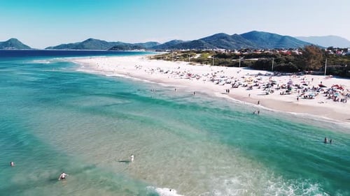 Luftaufnahme des Meeres mit sanften Wellen und Sandstrand mit Menschen, die sich darauf entspannen Campeche Beach