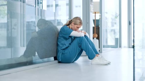 Woman, healthcare and sad nurse in hospital with regret, doubt and overwhelmed in career