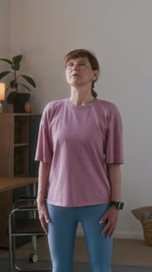 Woman Stretching Neck Indoors During Exercise
