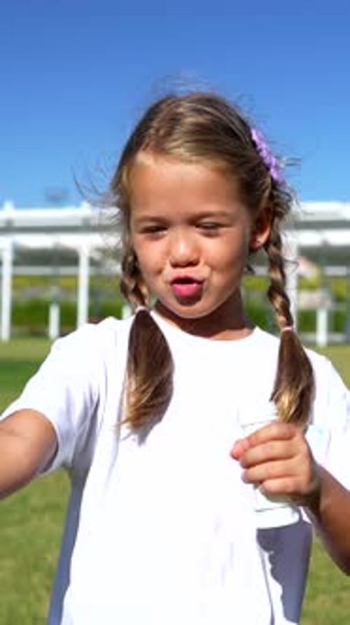 Little girl blowing soap bubbles in a park
