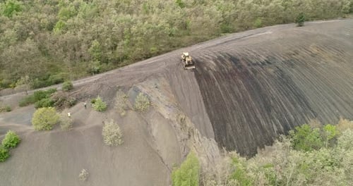 Bulldozer arbeitet an einem steilen Hang, Luftaufnahme