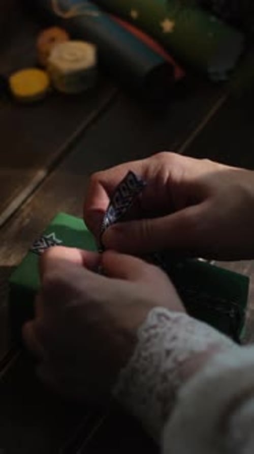 Hands Tie Festive Ribbon Around Gift Box