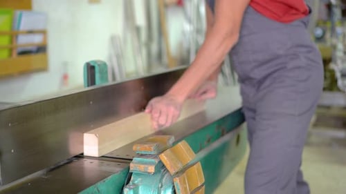 Unrecognizable Carpenter Trimming Wooden Plank in Workshop