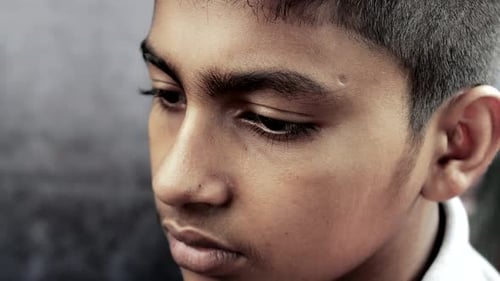 Trauriger Teenager, der sein Gesicht bedeckt, sitzt auf Sofa