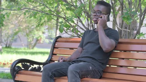 Young Adult Using Phone on Park Bench