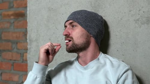 Bearded Man Taking a White Pill