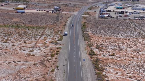 Aerial View of Nevada Desert Road with Trucks and Rolling Hills