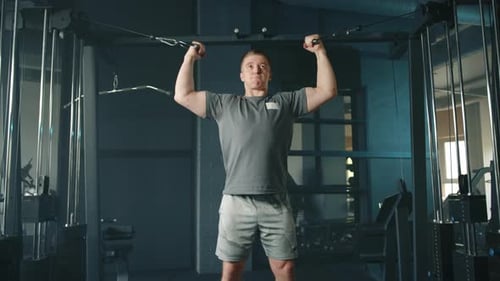 Young Athletic Man Performing Exercises on Cable Crossover Machine in Gym