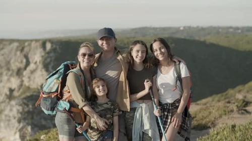 Happy Family Hiking Together Standing on Mountain Top