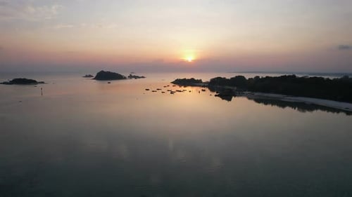 golden sunrise light hitting the turquoise waters of Belitung Island beach.