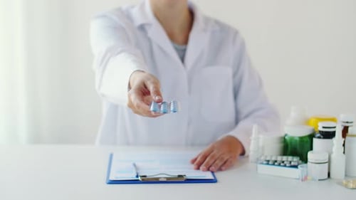 Medical Professional Offering Blister Pack of Pills at Clinic